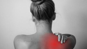kvinder der har smerter i skulderen og skulderbladet