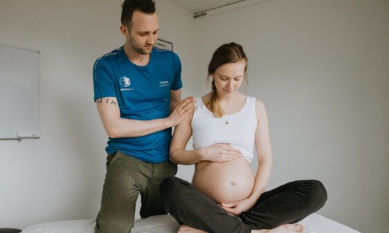 Fysioterapeut fra Smertefys ved siden af en gravid kvinde der er til massage på Østerbro i København