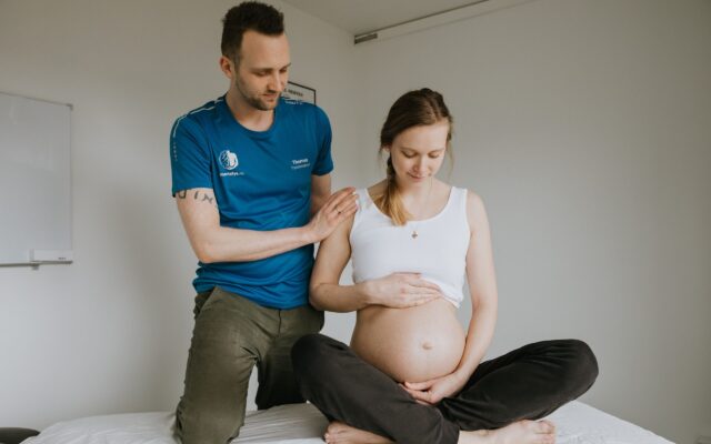 Fysioterapeut-fra-Smertefys-ved-siden-af-en-gravid-kvinde-der-er-til-gravidmassage-paa-Nørrebro-i-Koebenhavn-paa-grund-af-baekkenloesning